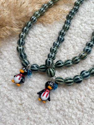 Eigenwijze ketting met pinguïn van glas, keramiek kralen en gouden of zilveren accenten – stijlvol en uniek.