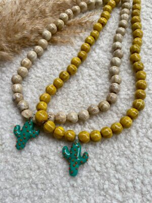 Zomerse ketting met Murano glazen cactus-bedel, gecombineerd met kleurrijke keramiek kralen en gouden of zilveren details, geïnspireerd op het warme zuiden.