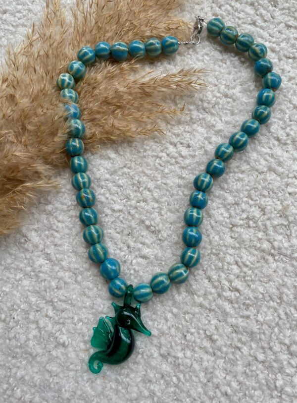 Sierlijke ketting met een Murano glas zeepaardje, keramieken kralen en stainless steel details, zomers en speels design