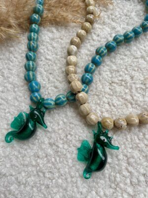 Sierlijke ketting met een Murano glas zeepaardje, keramieken kralen en stainless steel details, zomers en speels design